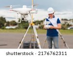 Small photo of A surveyor operating a drone to conduct topographic RTK or PPK aerial survey or photography of a plot of land.
