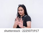 Small photo of A woman refuses to come closer. Looking disgusted and appalled. Hands gesturing to stop. Isolated on a white background.