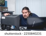 Small photo of A groggy man leans forward to get a clearer view of the a document shown on his computer monitor. Overworked and fatigued employee listlessly working at the office.