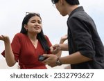 Small photo of A young woman denies any knowledge after being confronted by her boyfriend over salacious and flirty chats with another man on her cellphone. A desperate cheater in defensive mode.