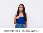 Small photo of A young asian woman caught aback loses a bit of composure. A shy lady pointing to herself looking slightly unnerved. Isolated on a white background.