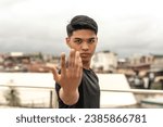 Small photo of A young cocky man makes a taunt gesture while doing boxing, mma or other combat sport drills. Daring you to come over here and get whooped.