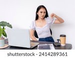 Small photo of Concerned and vehement young woman at her desk making a thumbs down sign, expressing dissatisfaction with her work.