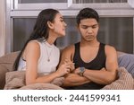 Small photo of Emotional distress visible as a young Asian woman seeks comfort from her partner after an unplanned pregnancy revelation with a home test.