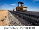 Small photo of Kyzylorda province, Kazakhstan, April 29, 2012: Construction of West Europe-West China road. Road layers. Caterpillar asphalt compactor flatten asphalt