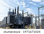 High voltage transformer against the blue sky. Electric current redistribution substation