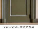 Small photo of View of a closed door inside an office or cafe. Beige tiles on the floor and granite baseboards along the wall. Evacuation exit from the building during a fire or other cataclysm. Emergency fire exit