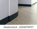 Small photo of The detail of the corner baseboard on the wall and granite tiles on the floor. A white wall with a copy space, decorated with decorative bricks and baseboards. Interior design in a office building.