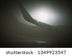 airplane wing on apron covered by dense fog during low visibility procedures at local airport