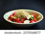 Small photo of Vegetable salad with the addition of alfalfa sprouts on a gray background. Salad of cucumbers, tomatoes and alfalfa sprouts. Healthy Eating.