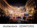 Small photo of 4 dec 2022, London- crowd and tourists walking around and taking photos in Piccadilly Circus, Soho area of London, during the christmas. surrounded by the iconic christmas lighting decoration