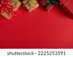 Christmas still life with gifts in the top of a red background. Copy ad space. Mockup, layout for promotional text. Boxing Day. Xmas and New Year's preparations. Packing presents. Web banner. Flat lay