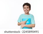 Small photo of Lovely primary school student, smart teen boy in blue casual tshirt, holding textbook and yellow pen, smiling a cute toothy smile looking at camera, isolated, white background. Copy advertising space