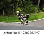 Sports, speed and safety, longboard skating in road, friends racing downhill with skateboard and helmet. Extreme sport adventure, skateboarding street race and skateboarder riding on mountain pass
