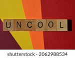 Small photo of Uncool, word in wooden alphabet letters isolated on colourful background