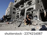 Small photo of Palestinians search a house after an Israeli air strike, in the city of Rafah, south of the Gaza Strip, on October 12 2023.