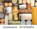 Small photo of Top view of the background of the necessary products for the period of the pandemic or famine or quarantine and isolation, food stock, the concept of stay at home, donated products, grocery delivery