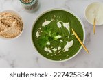 Healthy breakfasts, green broccoli and spinach cream soup with sunflower seeds and yogurt, buckwheat bread, top view