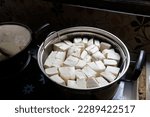 Small photo of white tofu in a stainless steel pot. Tofu is a food made from the coagulation of coagulated soy bean juice. Tofu originates from China. Tahu.