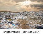 garbage dump pile in trash dump or landfill,backhoe and truck is dumping the gabage from municipal,garbage dump pile and dark sky background  ,pollution concept