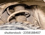 Small photo of torn boot of front wheel shock absorber strut of a passenger car will lead to suspension failure and unsteady car movement, selective focus