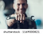 Auto Mechanic with Tool on Blurred Background. Close-up of Repairman Strong Fist Holding Metalic Wrench in Garage. Automobile Repair Service Concept. Automobile Master Concept