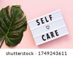 Self-care word on lightbox on pink background flat lay. Take care of yourself