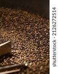 Small photo of coffee beans production operations, mixing roasted beans inside rotatory machine, Colombian import product