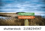 Small photo of Street Sign the Direction Way to Autonomy versus Dependency