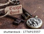 two old keys on a rusty metal table with labels : escape game