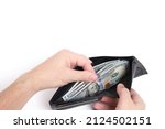 Small photo of Black leather wallet in hands with stack hundred dollar bills and bank cards on white background.Concept wealth and affluence
