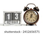 October 13 on wooden calendar with alarm clock white background