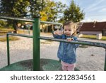 Small photo of One girl small caucasian child female toddler 18 months old in park play in day on speedy spinner merry-go-round turnabout childhood and growing up concept copy space