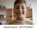 Small photo of one caucasian boy child at home with Deciduous primary milk teeth lost tooth fallen out dropped growing up concept copy space