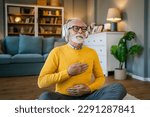 Small photo of one man mature senior caucasian male using headphones for online guided meditation practicing mindfulness yoga manifestation with eyes closed at home real people self care concept copy space