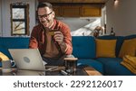 Small photo of One man adult mature caucasian male sit at home happy smile with laptop computer hold bank credit card online shopping buy on internet concept real people copy space e-commerce e-banking service