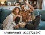 Couple man and woman caucasian husband and wife or boyfriend and girlfriend sit on the sofa bed at home watch tv movie series with bowl of popcorn happy smile bonding love family concept copy space