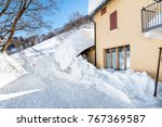 Entrance of the house hidden under the snow in winter mountains.
