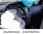 Small photo of The driver's airbag deployed on the steering wheel of the car after the collision. Deflated airbags after flared deployment. The airbag deployed. Car after an accident. Safety device in the car