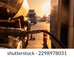 Filling the fuel tank of a truck at a gas station.