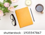 Workspace with modern notebook, stationery, cup of coffee on white table top view. Feminine concept, flat lay desk table