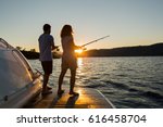 A Young Couple Fishing At Sunset