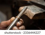 Small photo of Jeweler hands measuring and checking ring size gauge mandrel. Goldsmith working repairing a gold jewel in his jewelry workshop.