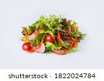 Beef Thai salad with herb mix and cherry tomatoes isolated on white background. Side view of fresh salad with veal pieces, carrot and bell pepper slices. Restaurant menu dish isolation