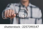 Small photo of Businessman holding a magnifying glass, showing Audit Document concept,quality assessment management With a checklist, business document evaluation process, market data report analysis and consulting