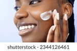 Small photo of Cream smear. Beauty and skincare. Skin hydration and oil balance. Portrait of African American young woman with afro braids hairstyle is applying cosmetic product on her face ans smiling