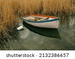 one boat moored near reed grass on Lake Ohrid during a cloudy day