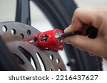 Small photo of lock the disc brake disc with a safety lock or padlock to anticipate motorcycle theft. anti theft lock concept