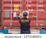 Small photo of Customs officers carry out investigations on import and export goods in containers. Customs officers at the port seal and inspect the container doors.