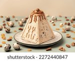 Traditional Easter cottage cheese dessert Paskha decorated with caramel, nuts, raisins and quail eggs on pastel background. Modern minimalistic Easter background with copy space for your design.